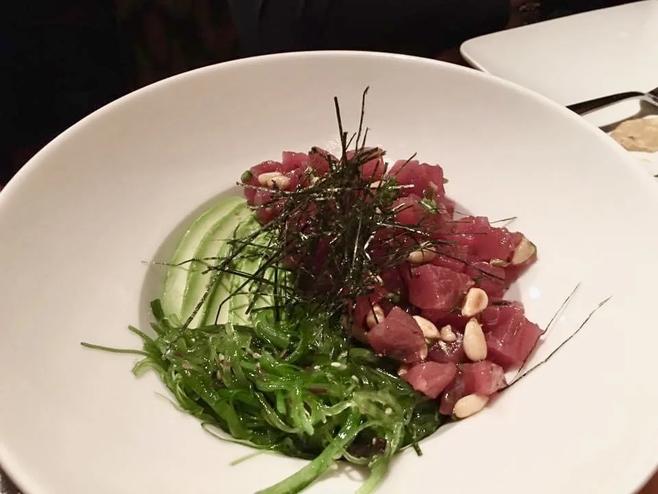 Tuna poke bowl with cucumber, peanuts, scallions, wakame, and shredded nori