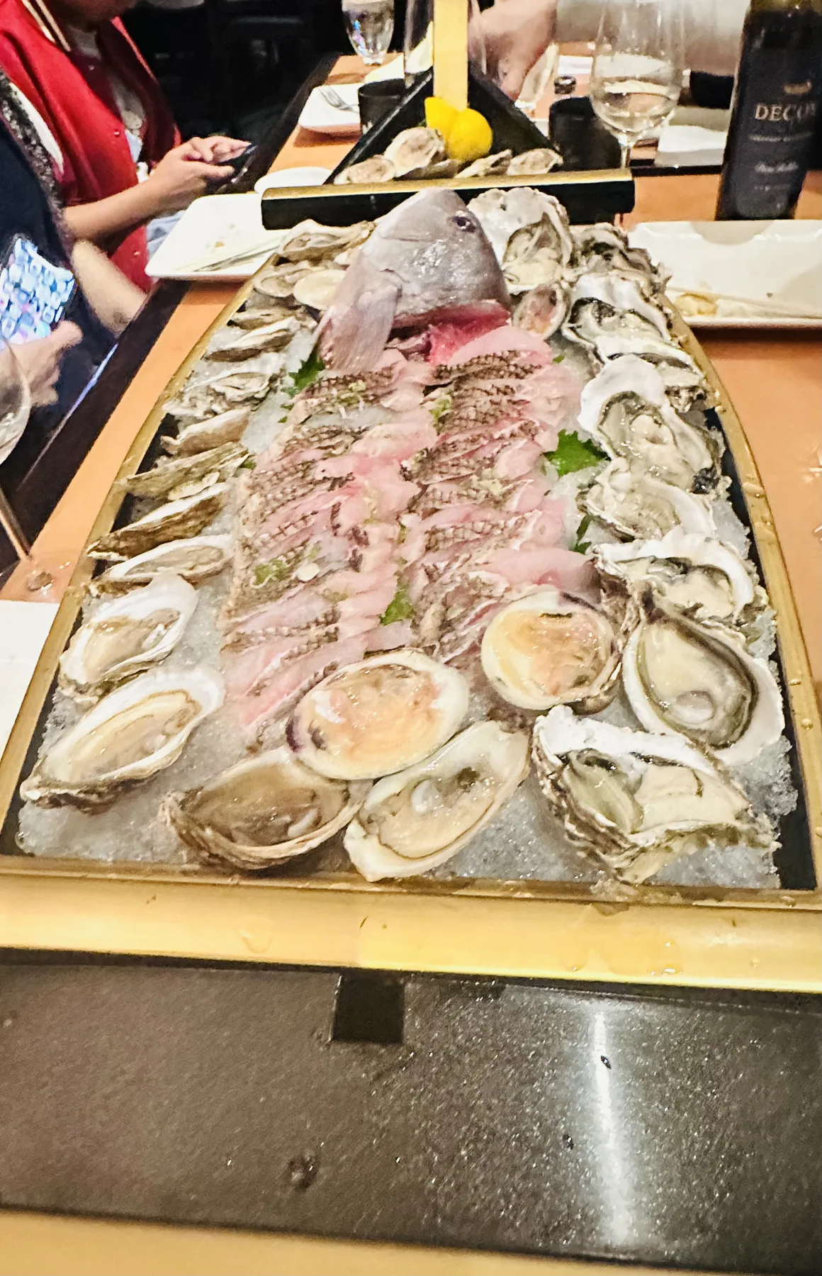 Large seafood platter with fresh oysters on the half shell and sashimi arranged on crushed ice